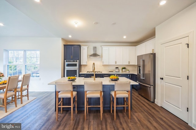305 Poplar Ave, Newark, DE 19711 - kitchen featuring a breakfast bar, dark wood-style flooring, appliances with stainless steel finishes, wall chimney range hood, and a center island with sink