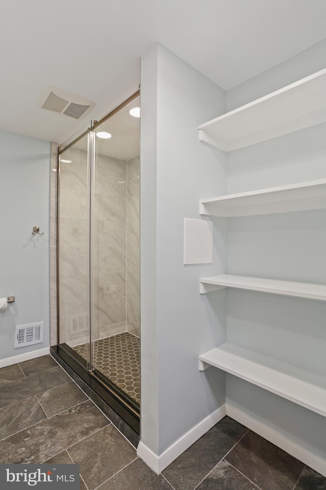 bathroom featuring baseboards, visible vents, and a stall shower
