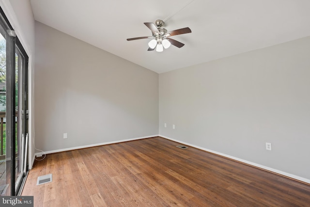 unfurnished room with vaulted ceiling, baseboards, visible vents, a ceiling fan, and wood finished floors