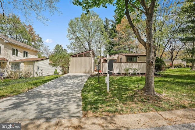 mid-century home featuring driveway and a front yard