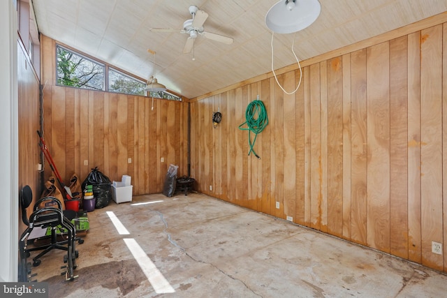 unfurnished room featuring wooden walls, vaulted ceiling, and ceiling fan