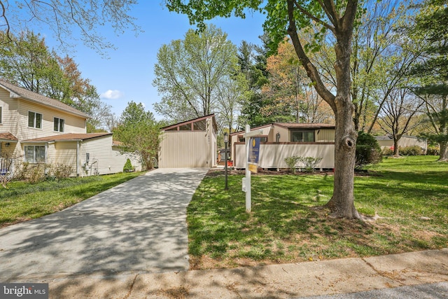 mid-century inspired home with a front yard and concrete driveway