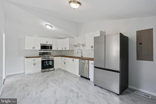 kitchen with electric panel, vaulted ceiling, visible vents, marble finish floor, and appliances with stainless steel finishes