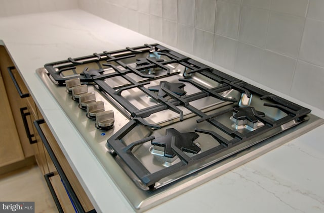 interior details with stainless steel gas cooktop and tasteful backsplash