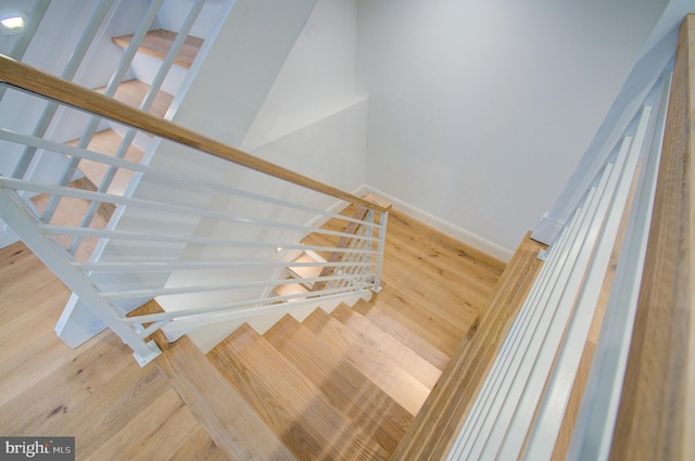 staircase with wood finished floors and baseboards