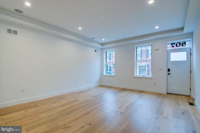 entryway with recessed lighting, visible vents, baseboards, light wood-style floors, and a tray ceiling