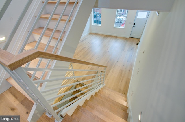 staircase with baseboards and wood finished floors