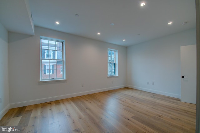 unfurnished room with baseboards, recessed lighting, and light wood-style floors