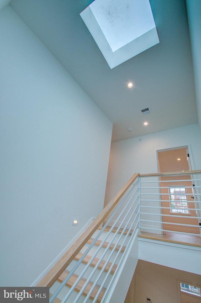 corridor with a skylight, visible vents, baseboards, and recessed lighting