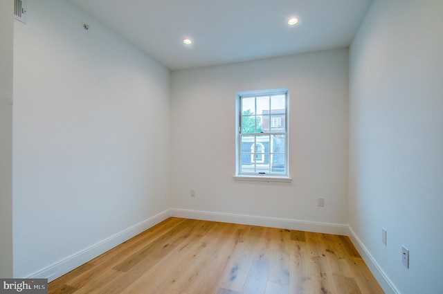 empty room with light wood-style flooring, baseboards, and recessed lighting