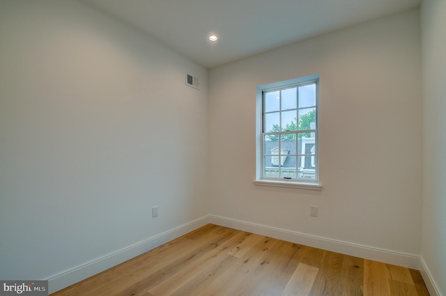 empty room with light wood-style floors, baseboards, visible vents, and recessed lighting