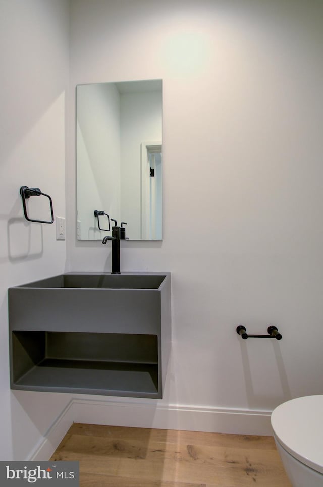 bathroom featuring vanity, wood finished floors, toilet, and baseboards