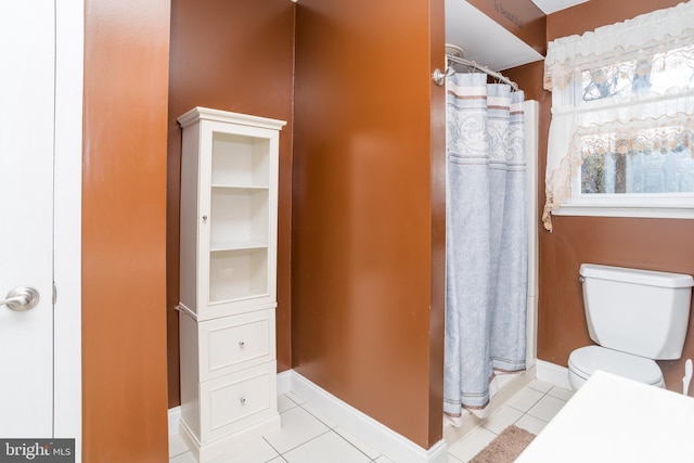 bathroom featuring toilet, baseboards, a shower with shower curtain, and tile patterned floors