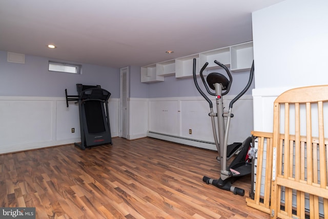 workout room featuring a baseboard heating unit, wainscoting, wood finished floors, and recessed lighting