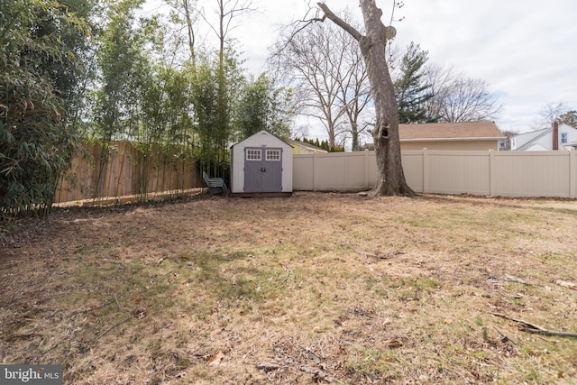 view of yard featuring a fenced backyard, a storage unit, and an outbuilding