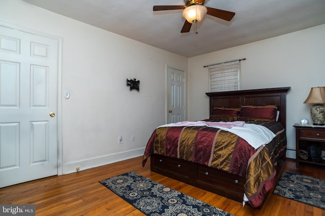 bedroom featuring a ceiling fan, baseboards, and wood finished floors