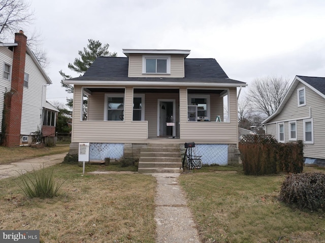 bungalow-style home featuring covered porch and a front lawn