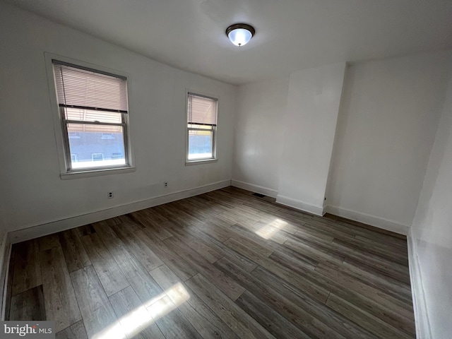 unfurnished room featuring baseboards and wood finished floors