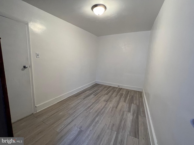 empty room featuring wood finished floors and baseboards