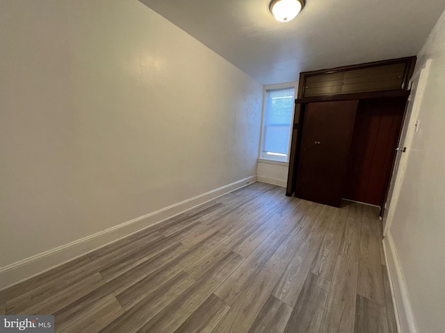 unfurnished bedroom with baseboards and dark wood finished floors