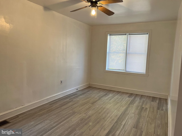 unfurnished room featuring visible vents, ceiling fan, baseboards, and wood finished floors