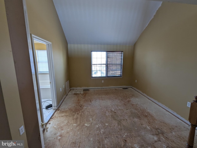 empty room featuring vaulted ceiling and a wealth of natural light