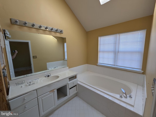 bathroom with tile patterned floors, a garden tub, vanity, and vaulted ceiling