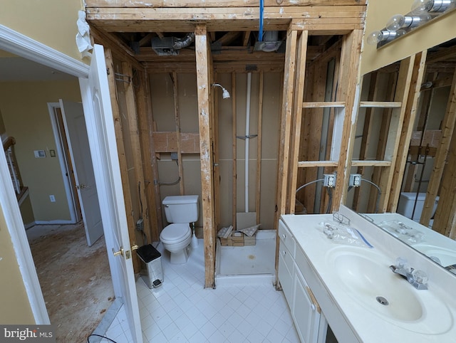 bathroom featuring vanity, toilet, and a stall shower