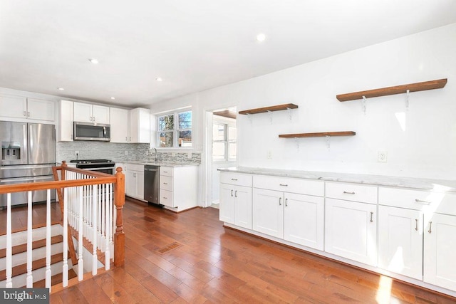 kitchen with dark wood-style floors, open shelves, white cabinets, appliances with stainless steel finishes, and backsplash