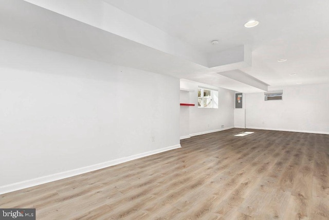 interior space featuring electric panel, recessed lighting, baseboards, and wood finished floors