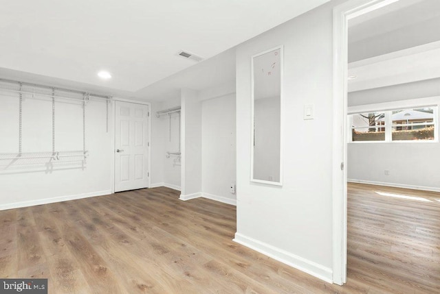 interior space with wood finished floors, baseboards, and visible vents