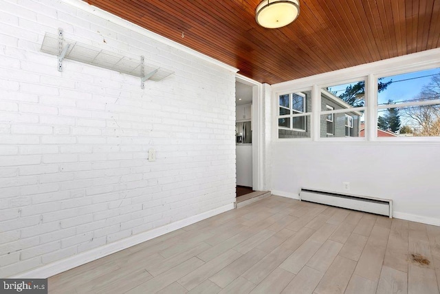 unfurnished sunroom featuring a baseboard heating unit and wood ceiling