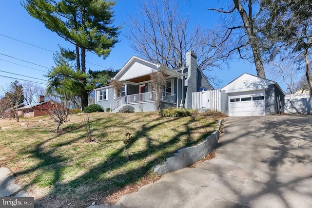 view of front of house featuring a front yard, fence, driveway, covered porch, and a chimney