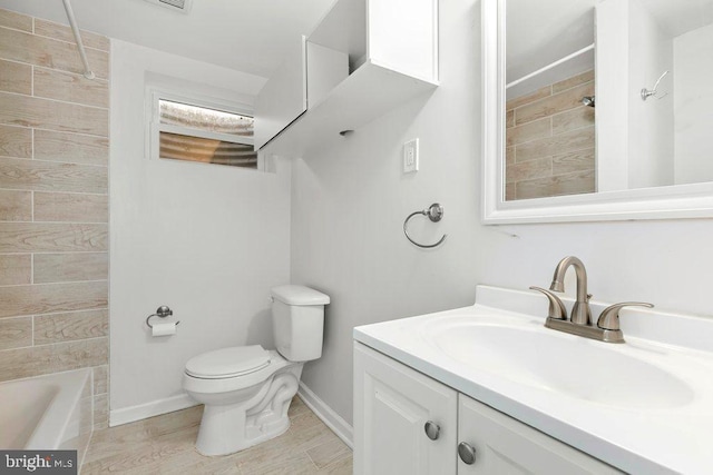 bathroom featuring toilet, vanity, and baseboards