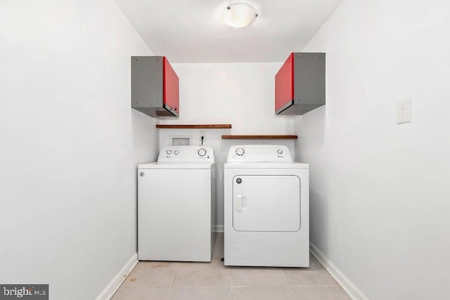 washroom featuring washer and dryer, laundry area, light tile patterned floors, and baseboards