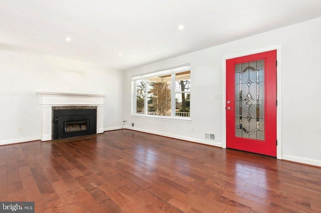 unfurnished living room with visible vents, baseboards, a fireplace with flush hearth, recessed lighting, and wood-type flooring