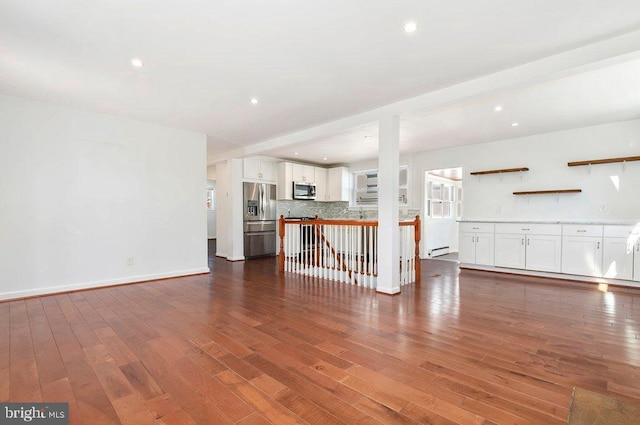 unfurnished living room featuring recessed lighting, a baseboard heating unit, baseboards, and dark wood-type flooring