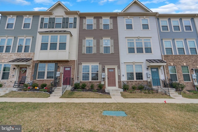 townhome / multi-family property with brick siding and a front lawn