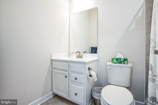 bathroom with toilet, tile patterned flooring, vanity, and baseboards