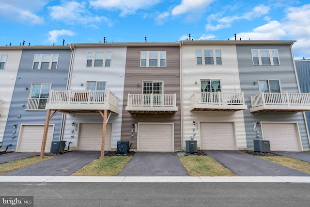 back of property with a garage, driveway, and central AC unit