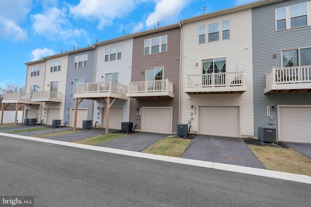 back of property featuring a garage, driveway, and central air condition unit