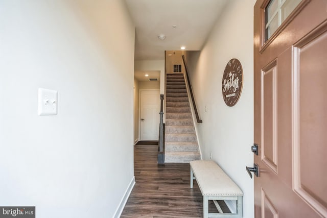 interior space with dark wood-style flooring, visible vents, stairway, and baseboards