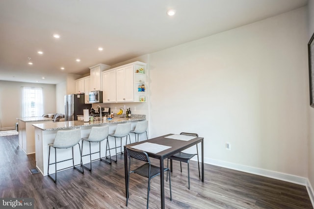 kitchen with dark wood finished floors, open shelves, appliances with stainless steel finishes, white cabinets, and baseboards