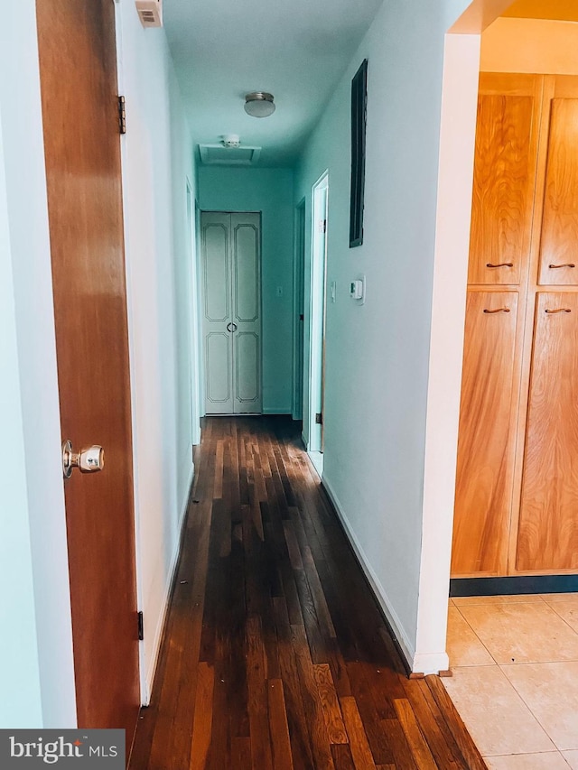 corridor with wood finished floors and baseboards