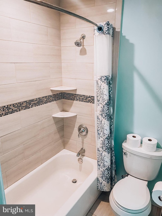 full bathroom featuring shower / bath combo with shower curtain and toilet