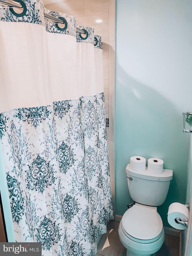 bathroom featuring toilet and a shower with curtain