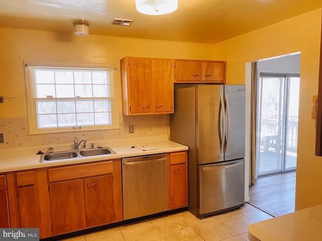 kitchen featuring appliances with stainless steel finishes, light countertops, visible vents, and a sink