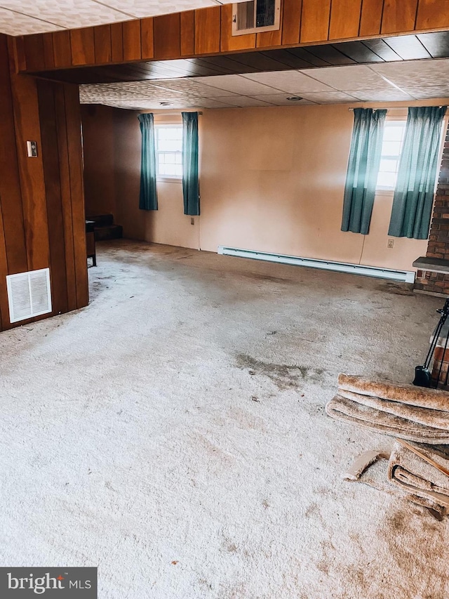 miscellaneous room featuring a baseboard heating unit, visible vents, and carpet flooring