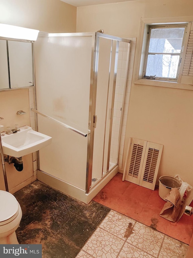 bathroom with toilet, a shower stall, visible vents, and a sink