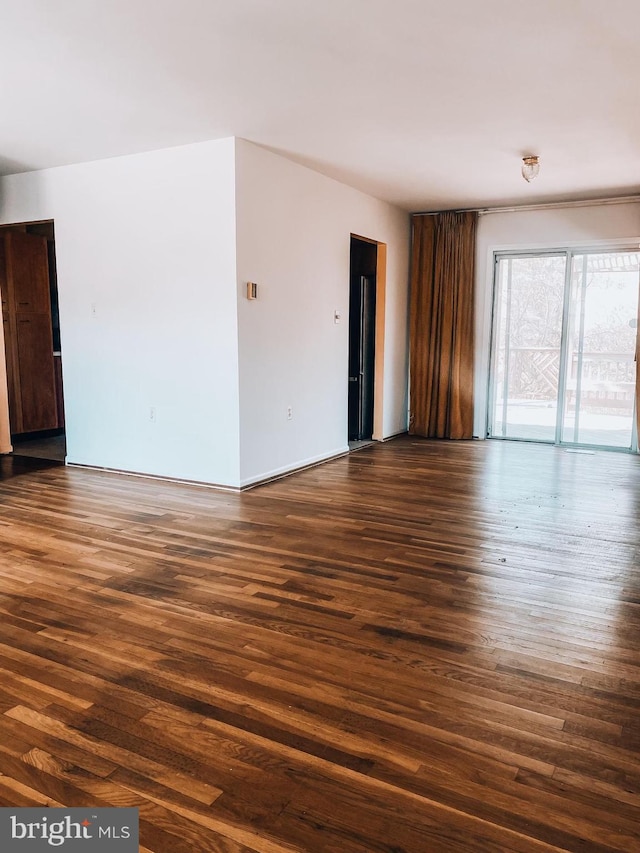 spare room with dark wood-style flooring